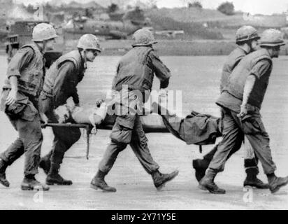 Khe Sanh , South Vietnam :Members of the 1st  Battalion 26th Regiment , 3rd US Marine division , carry a wounded comrade to a helicopter following communist artillery  and rocket attack on the US marine combat base  here  26 January .  The base is located seven miles below the demilitarized zone . 29n January 1968 Stock Photo