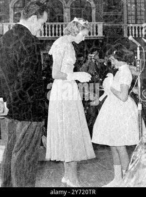 There was a touch of drama at the reception held in the inner court at the Monaco Palace, when Prince Rainier III and Princess Grace received guests. Among the guests were many bearing gifts, including two Monegasque girls with a white turtle dove - the traditional Monegasque symbol of good luck. Moments later, the flutter bird escaped from the bride's hands and flew off, much to almost tearful disappointment of the little donors.    Photo shows : - One of the little Monegasque girls about to present the white turtle dove to Grace.     19 April 1956 Stock Photo