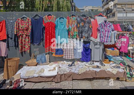 Belgrade, Serbia - August 10, 2024: Colourful Summer Dresses Hanging at Fence and Lace Needle Work for Sale at Flea Market Kalenic. Stock Photo