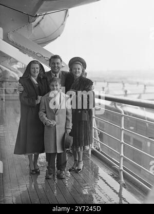 The Hollywood singing star Alan Jones, renowned on both sides of the Atlantic face singing of 'donkey Serenade', arrived at Southampton from New York in the SS America today (Wednesday). He was accompanied by his wife formally English actress Irene Harvey, and his son and daughter, John and Gail. Picture shows: Mr and Mrs Alan Jones pictured with Gail and John in the SS America at Southampton today. Mrs Jones is at left.    31st March 1948 Stock Photo