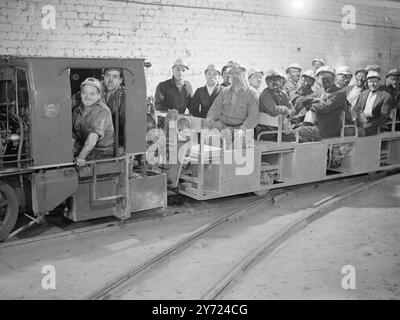 And hours extra work per man shift is expected to result from the installation of a diesel train from the shaft to the coalface 2 miles away at nook Colliery, Astley Lancashire. The train, first ever to be installed in the Lancashire coalfield draw 6 carriages, each carrying 2 men, at speeds varying from 4 to 14 mph. The journey now takes about 6 minutes against a former walk from 35 to 40 minutes duration. - - Picture shows: all aboard the underground railway-miners coming off shift by way of the new installed diesel railway. - - 2nd April 1948 Stock Photo