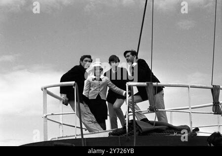 Pop singer Twinkle braves the wind and spray with pirate radio station ' Good Guys ' ( left to right ) Keith Skues, Bryan Vaughan and Don Allen , all disc jockeys, to take the tender out yesterday to Radio Caroline  moored off the English coast, for a champagne celebration launching the station's ' Good Guys ' project . Radio Carolin's record-spinning ' Good Guys ' will go out of their way to encourage good will and courtesy in all their broadcasts and appearances, and will present many big-prize competitions and new programmes on the air.  The idea for ' Good Guys ' , who have the distinctive Stock Photo