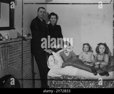 A new series of pictures of the nephew of Sir Charles Vyner Brooke, Rajah of Sarawak with his wife and children taken at their London home, 31 Prince Albert Road, NW8.   Picture Shows: Lionel 5 1/2 year old son of Mr and Mrs Brooke, is visited in his bedroom by the family during convalescence from an attack of flu.   Left to right:- Mr and Mrs Brooke, Lionel, Celia and Angela.  21 February 1946 Stock Photo