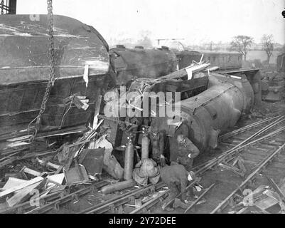 Two expresses with hundreds of passengers narrowly escaped disaster last night when a surburban train crashed into the platform at Potters Bar Station, near London. The King's Cross - Newcastle express ran into the wreckage. Another express from Bradford to London was pulled up just clear of the wreckage. Workers are trying to clear the wreckage at the scene of the crash. 11 February 1946 Stock Photo