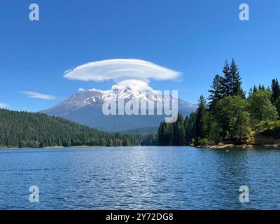 A large lenticular cloud over Mount Shasta in an otherwise deep blue sky Stock Photo