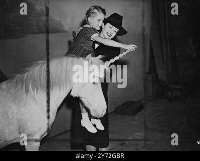 Little Margaret Julia Lockwood and her famous film star mother makes friends with the mythological animal - a white unicorn - on the set at Walton on Thames Studios.  The animal that never existed is really only a pony brought up from Maidstone Zoo to play the title role in 'The White Unicorn', in which Margaret Lockwood stars with Ian Hunter, Joan Greenwood and Dennis Price. 26 June 1947 Stock Photo