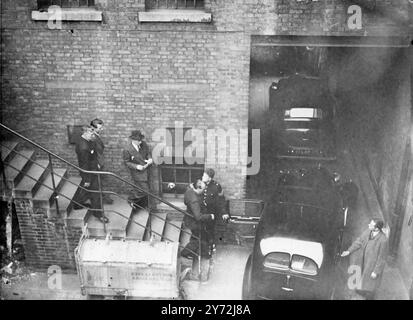 Three young men appeared at Gret Marlborough street Magistrates Court today, charged with the murder by shooting of Alec de Antiquis during a raid on a jewellers' of Charlotte Street, three weeks ago. The three men are Christopher James Geraghty, 20 year old labourer, of Liverpool Road, Charles Henry Jenkins, 23 year old lighterman of Weller House, Abbey Road, and Terrance John Peter Rolt, 17 year old waterhouseman, of St John's Estate Bermondsey. Picture Shows: One of the accused being escorted by detectives to a police car at Tottenham Court road Police Station on the way to Marlborough stre Stock Photo