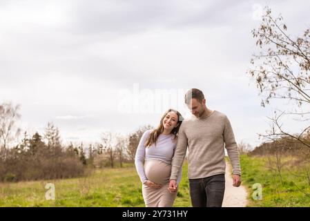 schwangere junge Frau mit Partner im Park *** Pregnant young woman with partner in the park Stock Photo