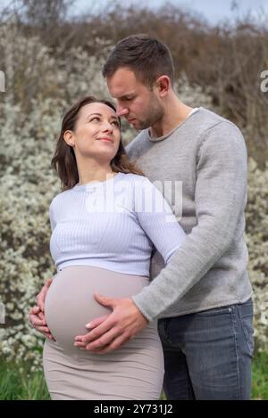 schwangere junge Frau mit Partner im Park *** Pregnant young woman with partner in the park Stock Photo