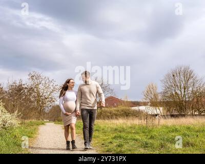 schwangere junge Frau mit Partner im Park *** Pregnant young woman with partner in the park Stock Photo