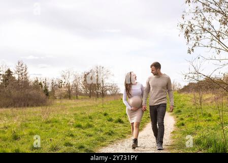 schwangere junge Frau mit Partner im Park *** Pregnant young woman with partner in the park Stock Photo