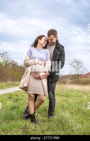 schwangere junge Frau mit Partner im Park *** Pregnant young woman with partner in the park Stock Photo