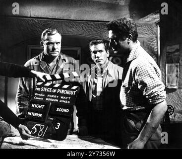 Ealing Studios. The filming of the British thriller, The Siege of Pinchgut at Ealing Studios.  Photo shows ; The clapper board goes down for action in the studio on a tense scene with US movie star, Aldo Ray ,   Neil McCallum and Carlos Justini .  1958 Stock Photo