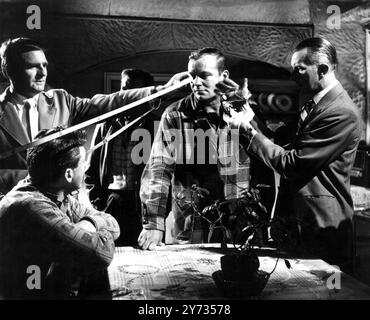 Ealing Studios. The filming of the British thriller, The Siege of Pinchgut at Ealing Studios.  Photo shows ;  Film technicians measuring distances and taking a light reading before filming a scene with US actor , Aldo Ray.  1958 Stock Photo