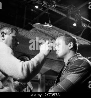 Ealing Studios. The filming of the British thriller, The Siege of Pinchgut at Ealing Studios.  Photo shows ; A break in filming  while US actor , Aldo Ray has his make-up seen to.  1958 Stock Photo