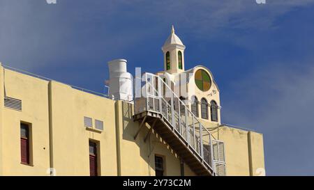 759 Hexagonal lantern atop cross-shaped architectural body, rooftop of yellow-painted modern building with exterior stairway on the wall. Havana-Cuba. Stock Photo