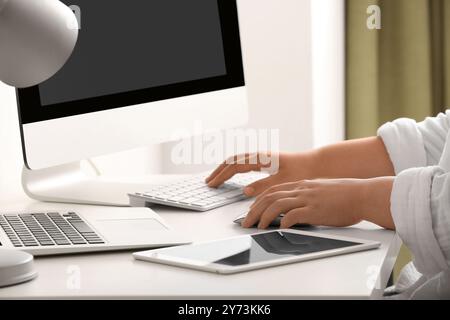 Female programmer working with keyboard and tablet computer at her workplace in office, closeup Stock Photo