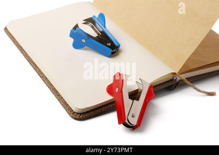 Open notebook and staplers on white background Stock Photo