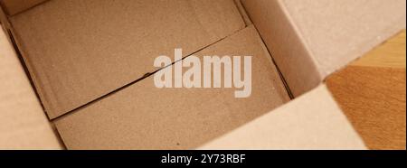 Empty cardboard box a wooden floor. Close up. Stock Photo