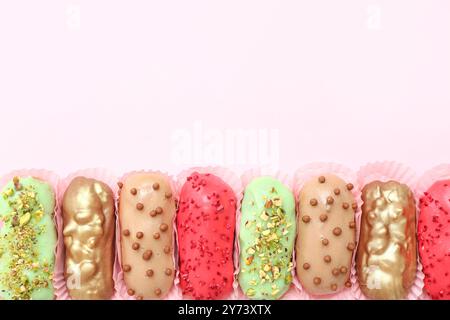 Various glazed eclairs on pink background Stock Photo
