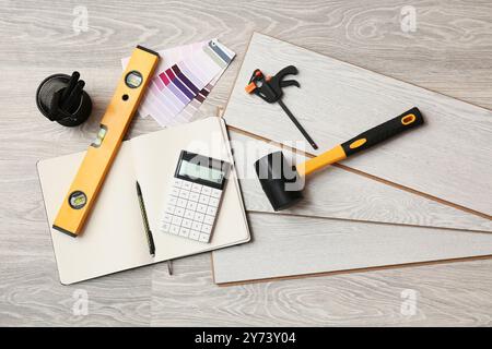 Tools, calculator, notebook and laminate boards on floor Stock Photo