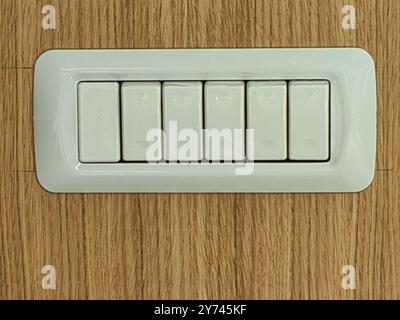 White Plastic Power Switch Buttons – Lighting Control Perspective on Wooden Wall Stock Photo