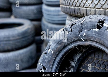 An old blown out car tire in a used tire landfill. Old tires polluting the environment Stock Photo