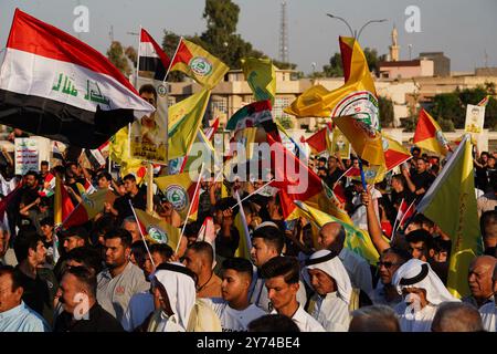 Mosul, Iraq. 27th Sep, 2024. Supporters of Kataeb Sayyid al-Shuhada armed faction (member of the Hashed al-Shaabi/Popular Mobilisation Forces or PMF) hold a flags during a solidarity stand against the Israeli aggression on Lebanon and Palestine near the Great Mosque (not in view) of Mosul in the city of Mosul, Iraq. Credit: SOPA Images Limited/Alamy Live News Stock Photo