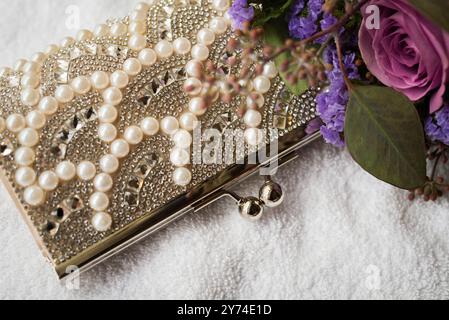 Close up photography of a woman's clutch purse beside purple flowers Stock Photo