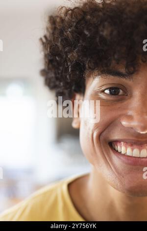 Smiling young man with curly hair  indoors, at home, copy space Stock Photo