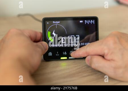 A person checking on energy usage on a home smart meter. A technology use concept. Stock Photo