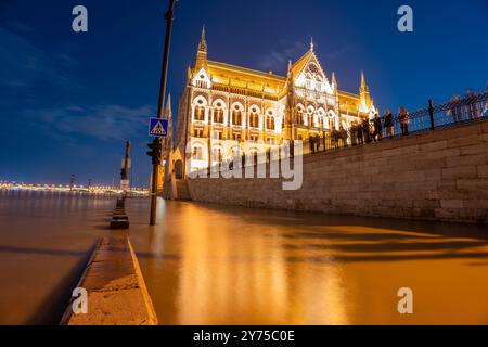 Budapest, Hungary - September 18, 2024: Flooded Danube river. Parliament building on the background. Night long exposure shot. Stock Photo