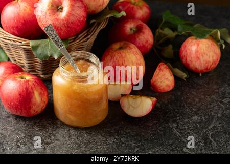 Apple jam and red fresh apples on a black stone table. Stock Photo