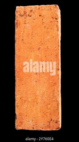 Single cracked old red or orange brick is isolated on black background with clipping path. Stock Photo