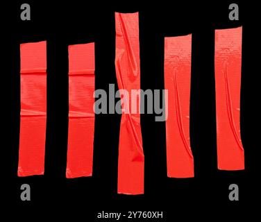 Top view set of red adhesive vinyl tape or cloth tape stripes is isolated on black background with clipping path. Stock Photo