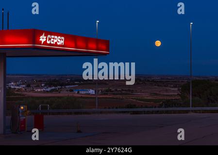 Canopy of a Cepsa service station with a full moon in the background during the blue hour of dawn. Stock Photo