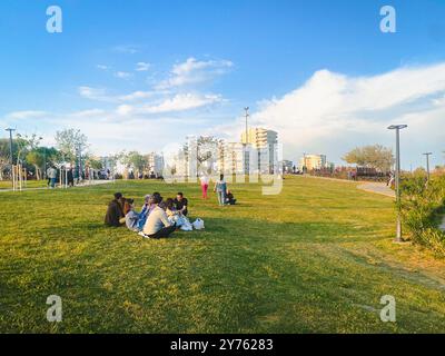 People relax in Duden park in Antalya with high rise city apartment blocks beyond Stock Photo