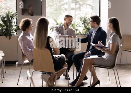 Happy successful business colleagues shaking hands, making deal Stock Photo