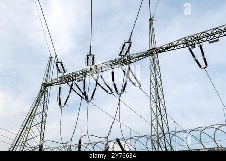 Electrical substation power station equipment towers on a cloudy sky background, detail shot, nobody. Fuel and power generation and distribution indus Stock Photo
