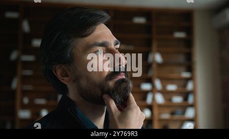 Thoughtful businessman psychotherapist portrait specialist Caucasian psychologist guy mature man male touching beard chin face friendly looking camera Stock Photo