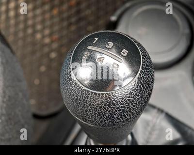 Gear stick top 5 gears gearbox gear shift knob in an older car extreme closeup detail, nobody, top view. Learning to use vehicle manual transmission s Stock Photo