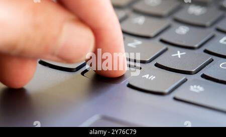 Man pressing a blank generic operating system key on a new modern laptop computer keyboard finger closeup, one person's hand, unknown empty OS key bei Stock Photo