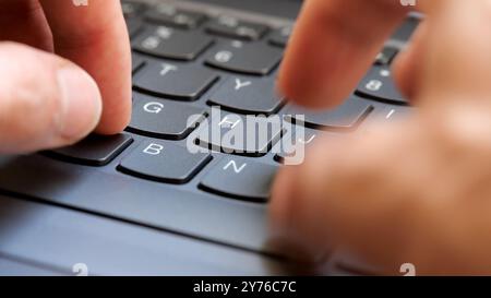 Man typing fast on a new gray modern laptop keyboard, closeup, real time, one person. Creative content writing, quickly typing something on a keyboard Stock Photo