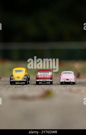 Woodbridge, New Jersey - September 27, 2024: Three diecast toy cars, a 1976 Volkswagen Beetle, a 1955 Chevy Nomad, and a 1953 Cadillac, are parked out Stock Photo