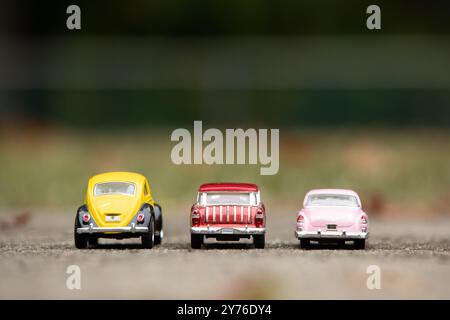 Woodbridge, New Jersey - September 27, 2024: Three diecast toy cars, a 1976 Volkswagen Beetle, a 1955 Chevy Nomad, and a 1953 Cadillac, are parked out Stock Photo