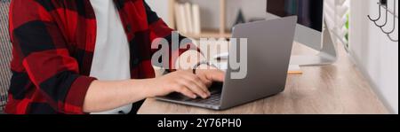 Programmer working with laptop in office, closeup. Banner design Stock Photo