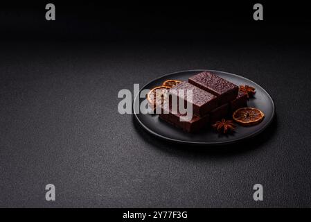 Rectangular chocolate candies with mousse and waffles on a dark concrete background Stock Photo