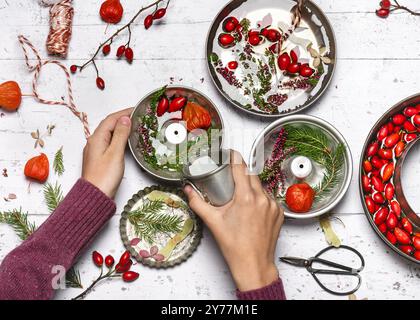 Step by step introduction of easy homemade ice frozen decoration in donut form. Child pouring water into the baking pans. Top view. Stock Photo