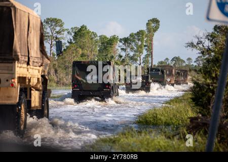 Florida National Guard soldiers from the 3-265th Air Defense Artillery clear road debris in Cedar Key following Hurricane Helene while assisting law enforcement at a checkpoint as part of their route clearing patrol on September 27, 2024. (USA) Stock Photo