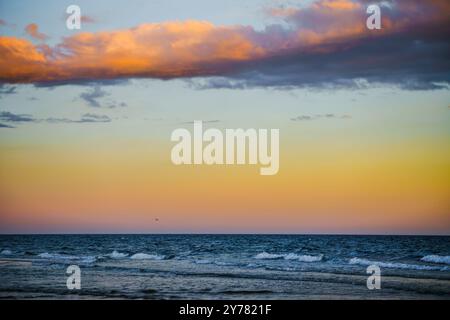 Beautiful gradient sky transitioning from orange to blue above the sea. Stock Photo